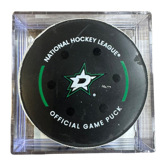 A Dallas Stars NHL official game/goal puck inside a clear plastic protective case, shown against a plain white background.
