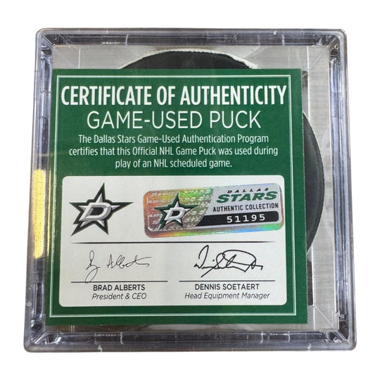 A game-used hockey puck in a clear plastic protective case with a green and white Certificate of Authenticity insert. COA 