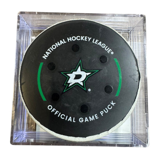 A Dallas Stars NHL official game/goal puck inside a clear plastic protective case, shown against a plain white background.
