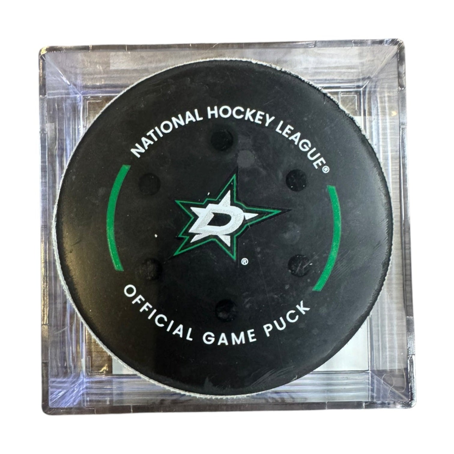 A Dallas Stars NHL official game/goal puck inside a clear plastic protective case, shown against a plain white background.
