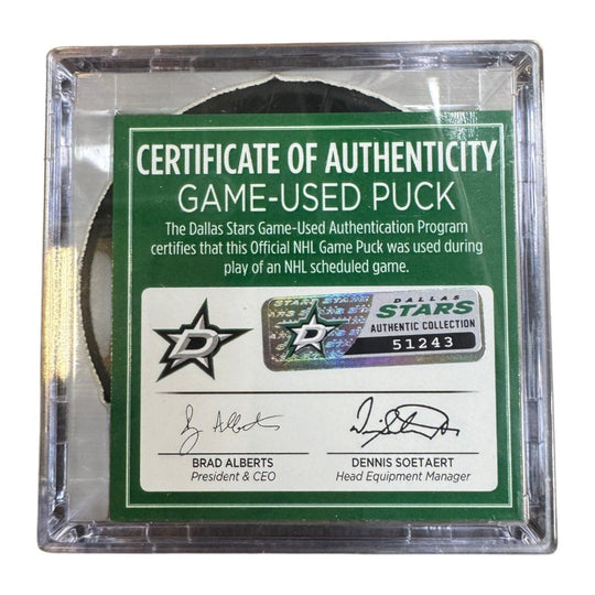 A game-used hockey puck in a clear plastic protective case with a green and white Certificate of Authenticity insert. COA 