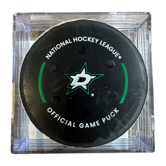 A Dallas Stars NHL official game/goal puck inside a clear plastic protective case, shown against a plain white background.
