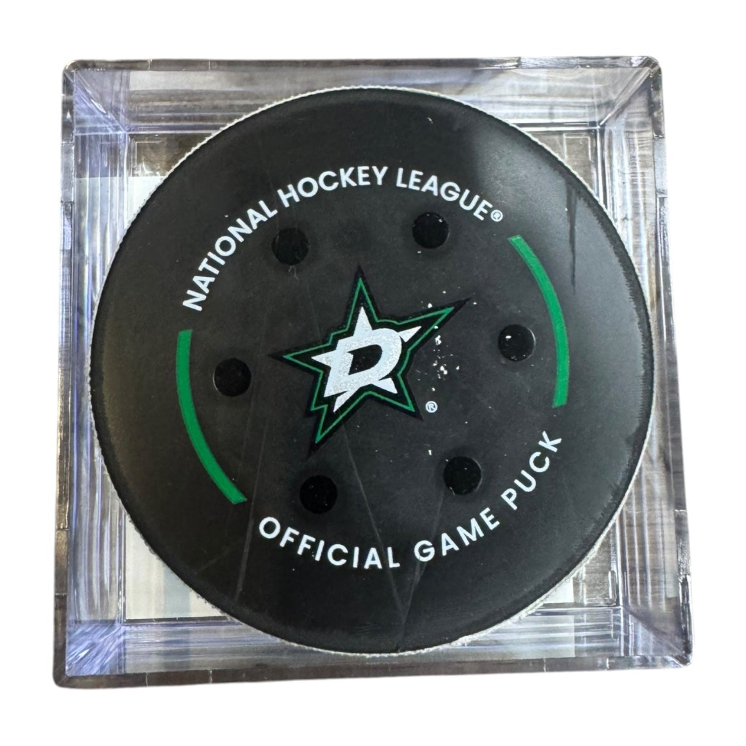 A Dallas Stars NHL official game/goal puck inside a clear plastic protective case, shown against a plain white background.
