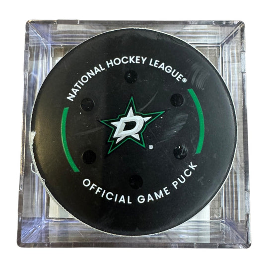 A Dallas Stars NHL official game/goal puck inside a clear plastic protective case, shown against a plain white background.
