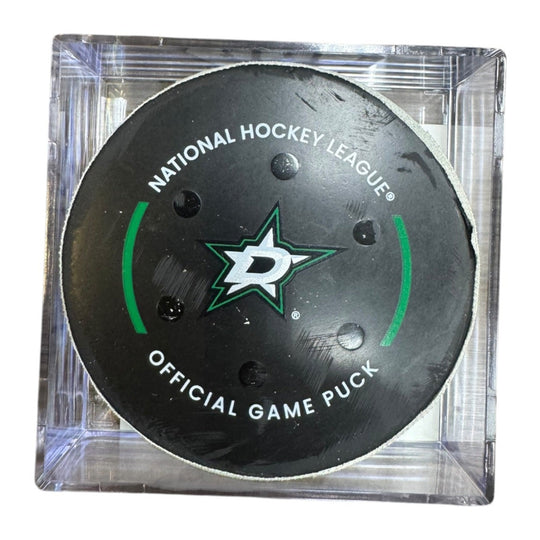 A Dallas Stars NHL official game/goal puck inside a clear plastic protective case, shown against a plain white background.

