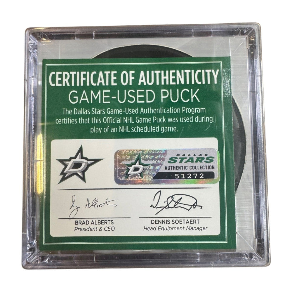 A game-used hockey puck in a clear plastic protective case with a green and white Certificate of Authenticity insert. COA #  51272

