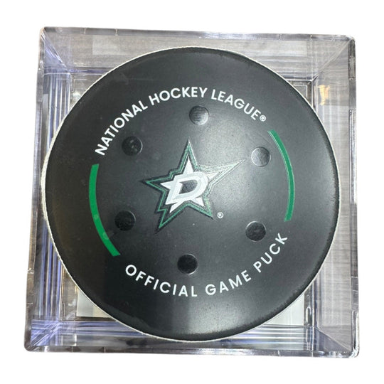 A Dallas Stars NHL official game/goal puck inside a clear plastic protective case, shown against a plain white background.
