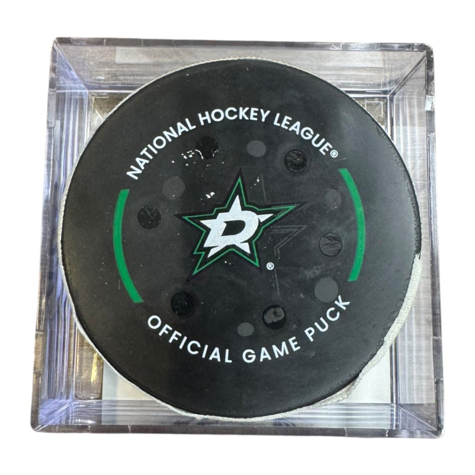 A Dallas Stars NHL official game/goal puck inside a clear plastic protective case, shown against a plain white background.
