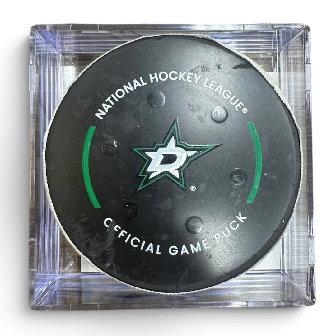 A Dallas Stars NHL official game/goal puck inside a clear plastic protective case, shown against a plain white background.