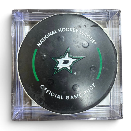 A Dallas Stars NHL official game/goal puck inside a clear plastic protective case, shown against a plain white background.