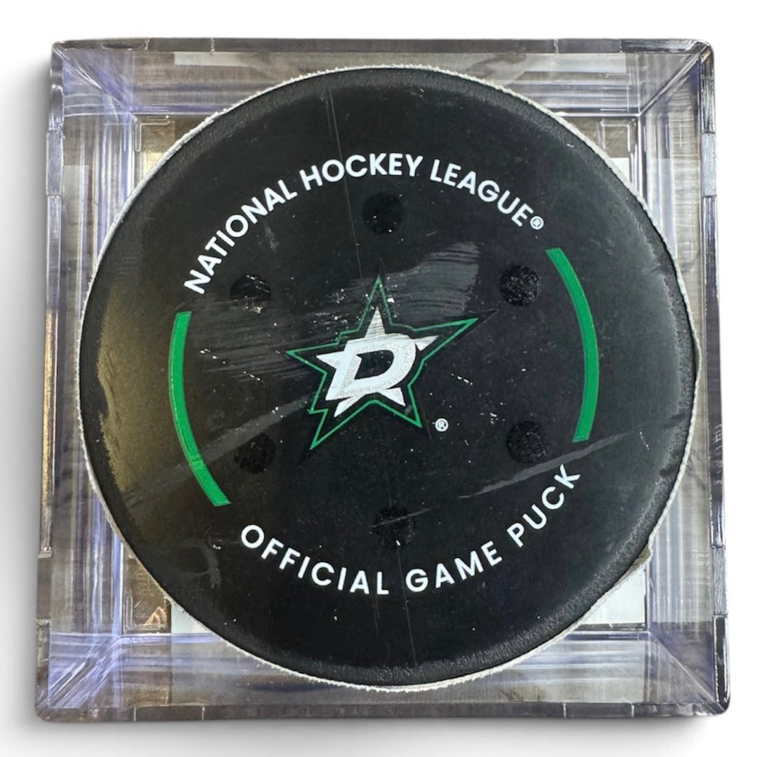 A Dallas Stars NHL official game/goal puck inside a clear plastic protective case, shown against a plain white background.