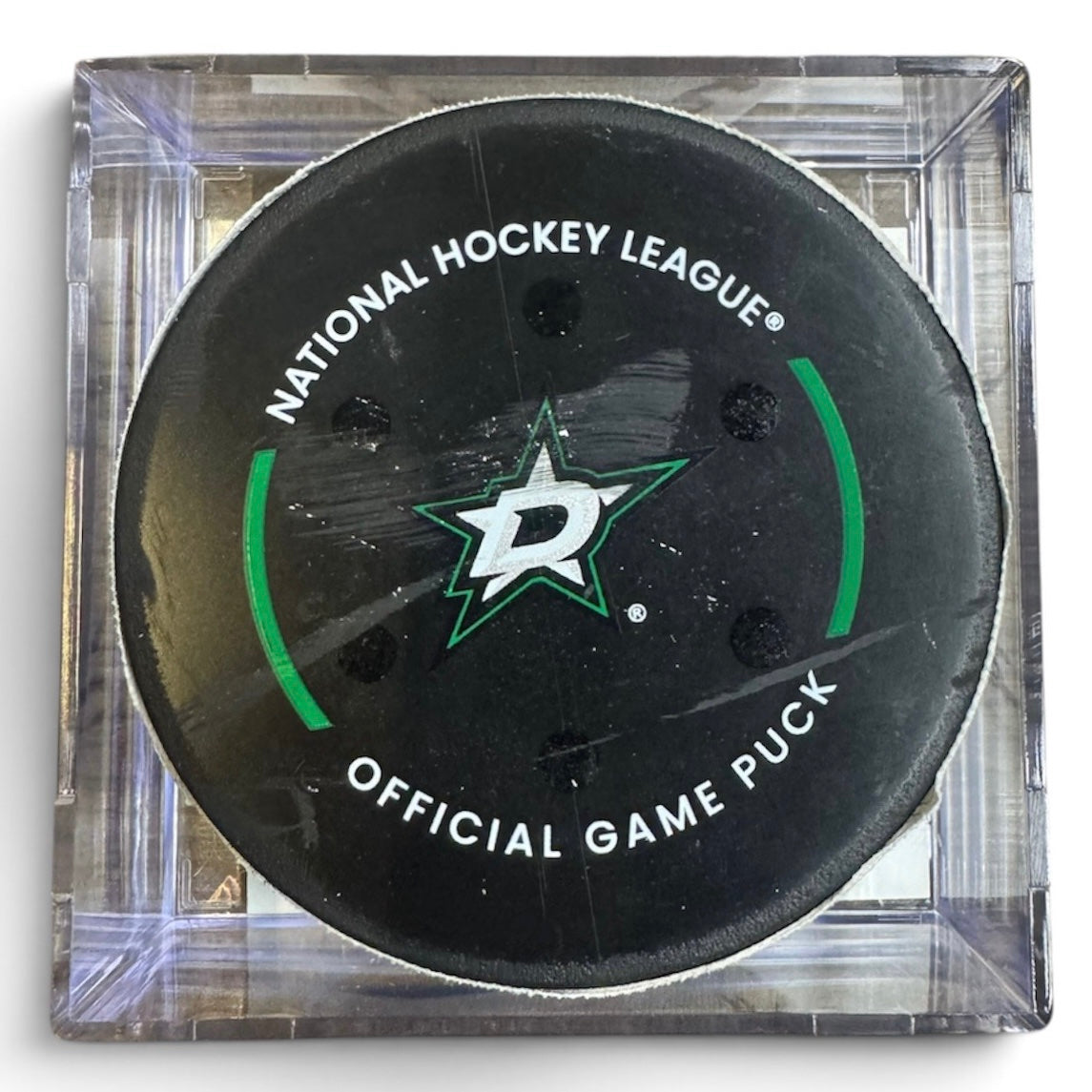 A Dallas Stars NHL official game/goal puck inside a clear plastic protective case, shown against a plain white background.