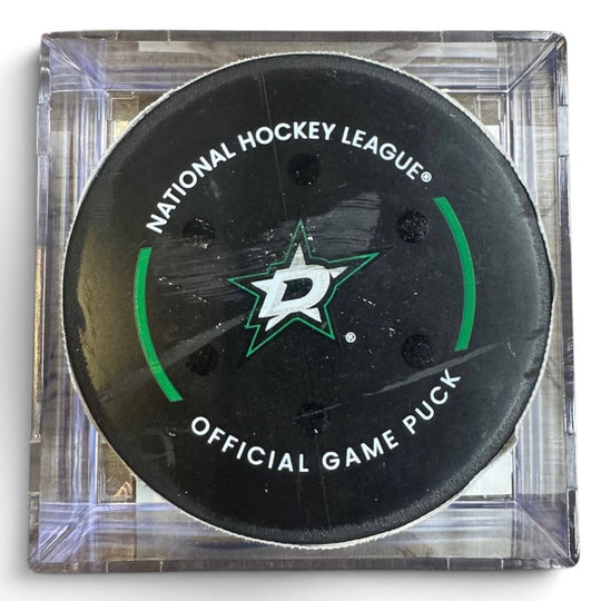 A Dallas Stars NHL official game/goal puck inside a clear plastic protective case, shown against a plain white background.