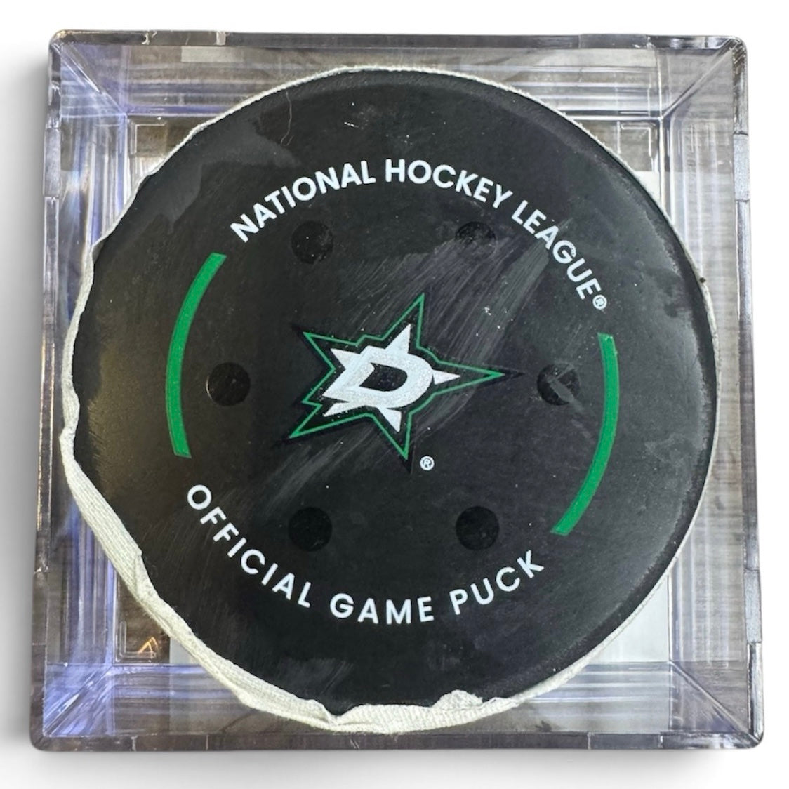 A Dallas Stars NHL official game/goal puck inside a clear plastic protective case, shown against a plain white background.