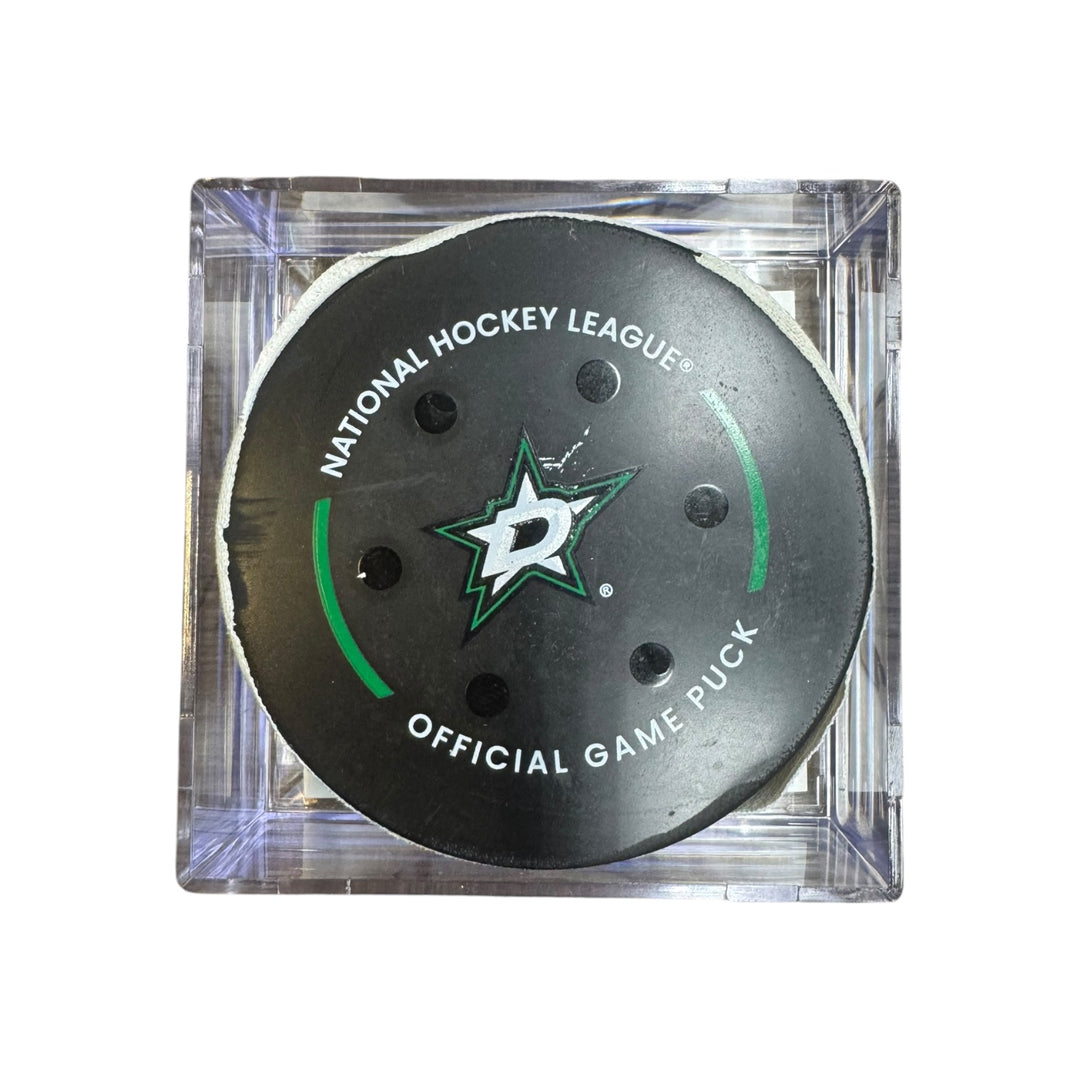 A Dallas Stars NHL official game/goal puck inside a clear plastic protective case, shown against a plain white background.