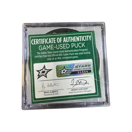 A game-used hockey puck in a clear plastic protective case with a green and white Certificate of Authenticity insert. COA 
