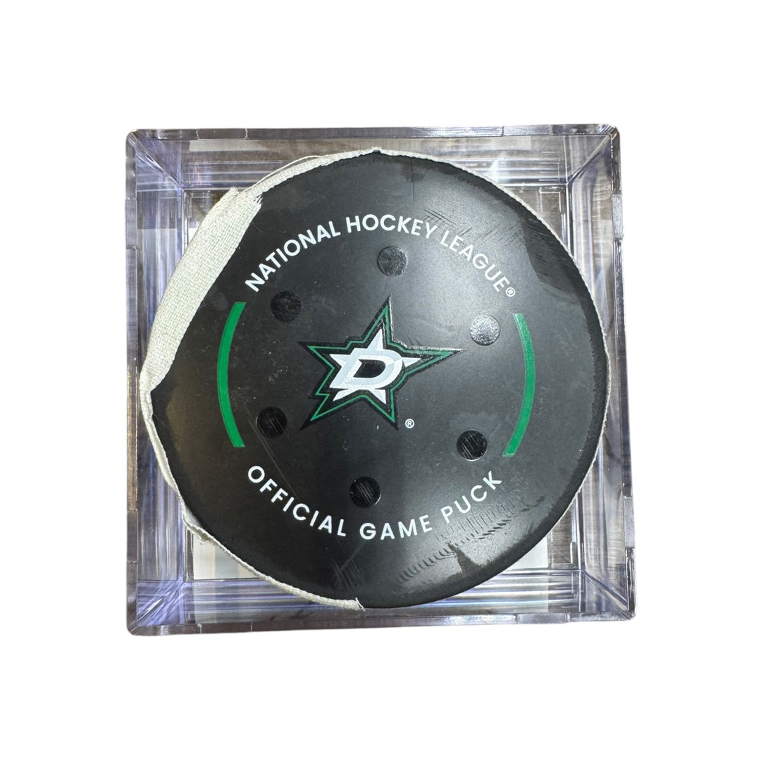 A Dallas Stars NHL official game/goal puck inside a clear plastic protective case, shown against a plain white background.