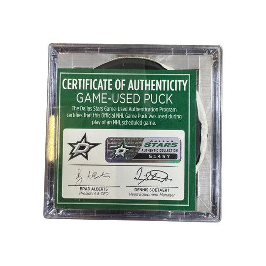 A game-used hockey puck in a clear plastic protective case with a green and white Certificate of Authenticity insert. COA 