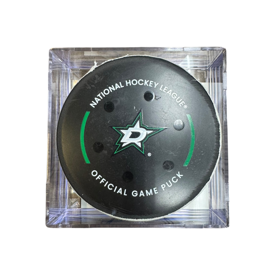 A Dallas Stars NHL official game/goal puck inside a clear plastic protective case, shown against a plain white background.