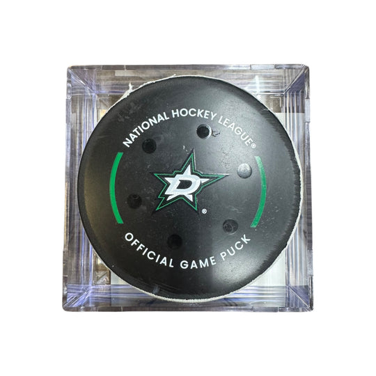 A Dallas Stars NHL official game/goal puck inside a clear plastic protective case, shown against a plain white background.