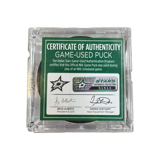 A game-used hockey puck in a clear plastic protective case with a green and white Certificate of Authenticity insert. COA 