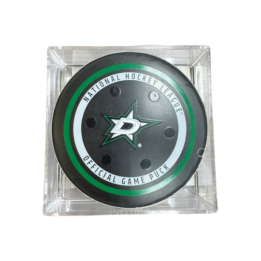 A Dallas Stars NHL official game/goal puck inside a clear plastic protective case, shown against a plain white background.
