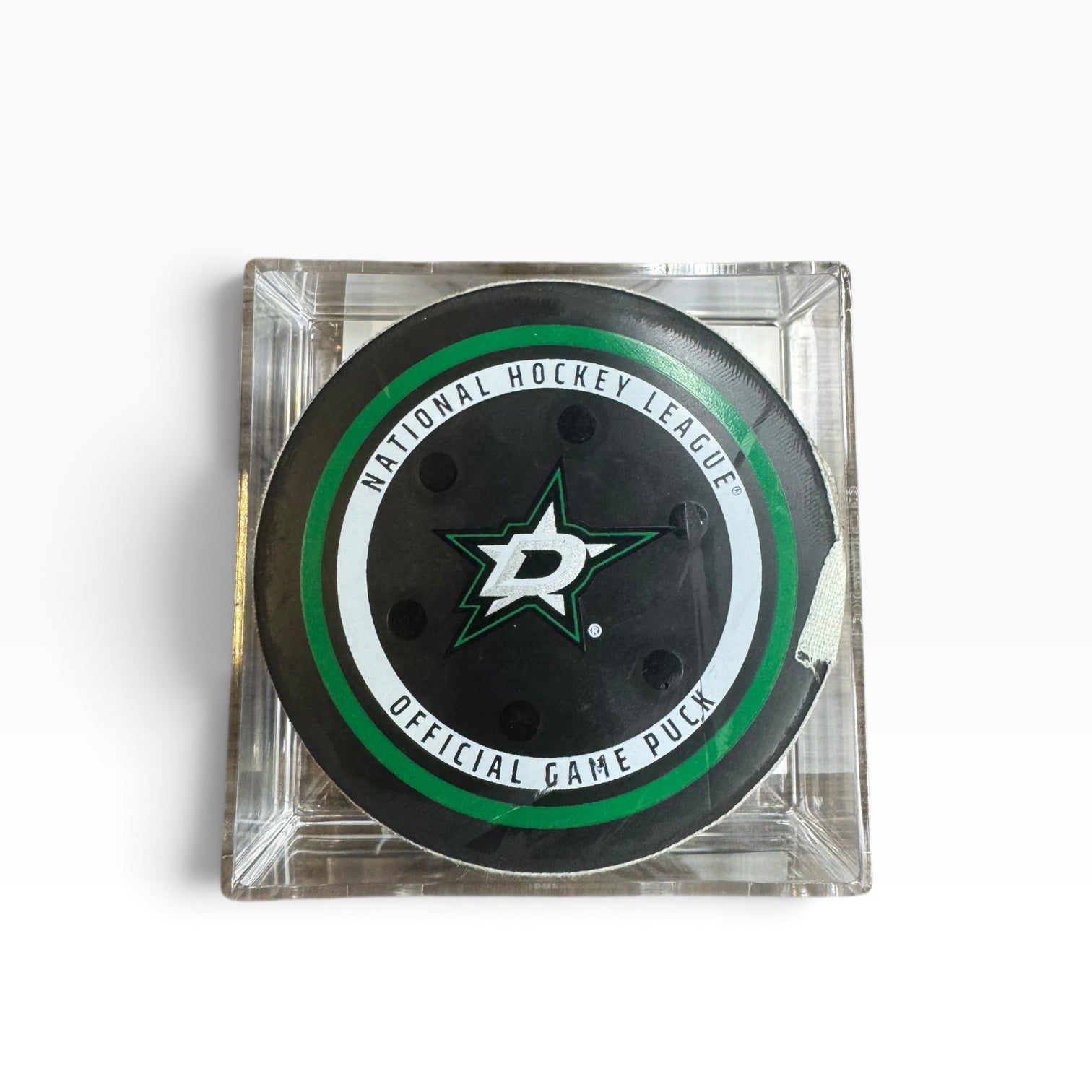 Dallas Stars official playoff hockey game puck displayed inside a clear square acrylic case on a white background.