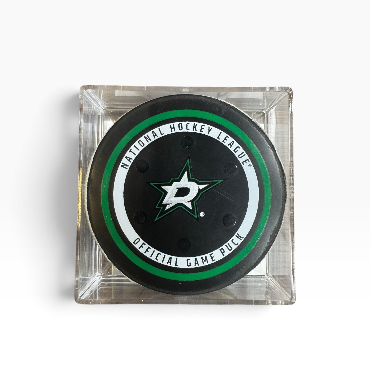 An official NHL playoff hockey puck in a clear acrylic display case, featuring a black puck with white text and the Dallas Stars logo.