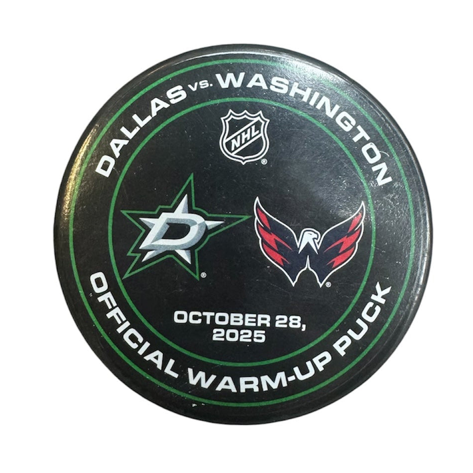 Warm up used Hockey puck with Dallas Stars and Washington Capitals logos on a white background. Used on October 28th, 2025