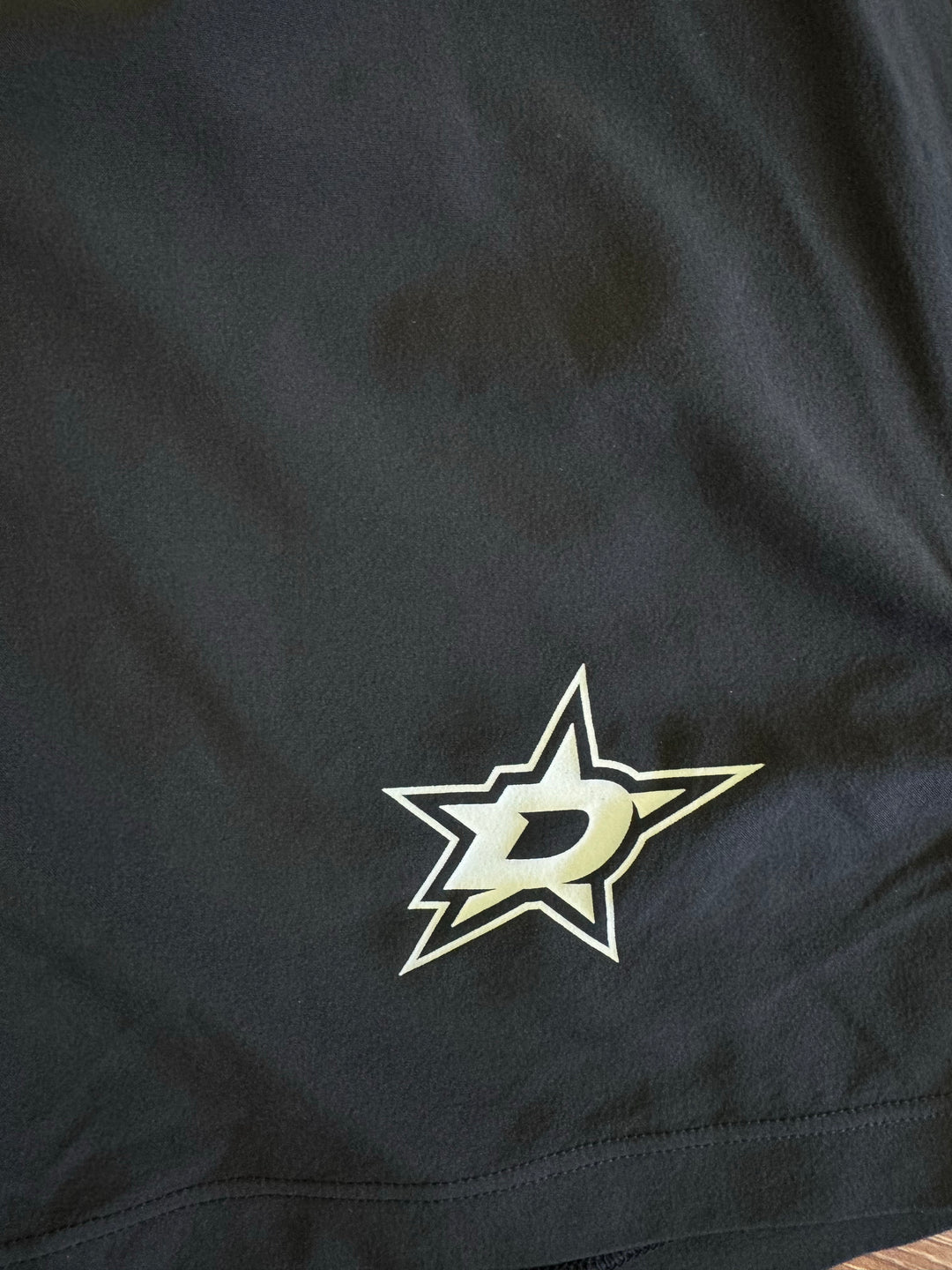 Close-up of a black fabric surface with a Dallas Stars logo patch in white