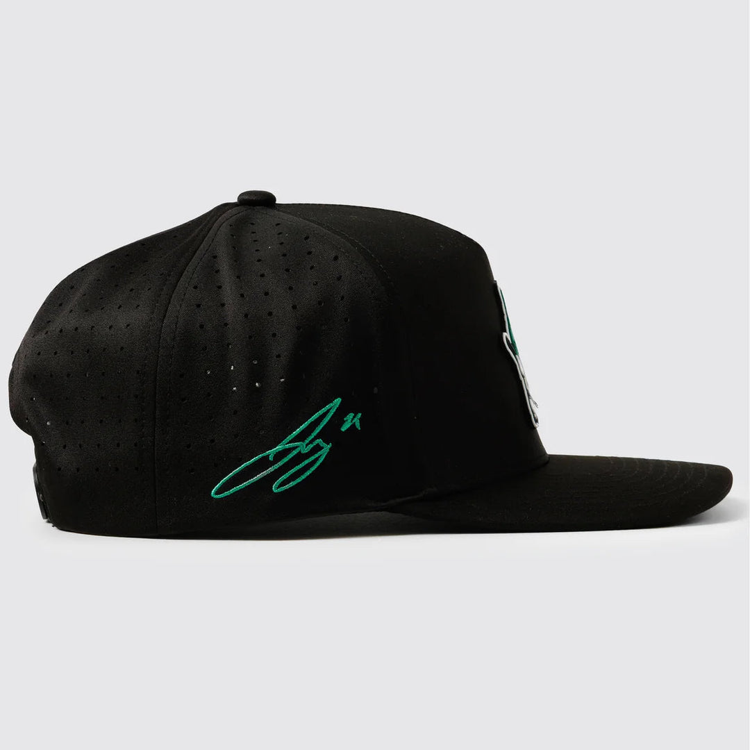 A black structured baseball cap with a flat brim, featuring a green embroidered Jake Oettinger signature on the side and a small white ‘waggle’ on the opposite side, set against a light gray background.