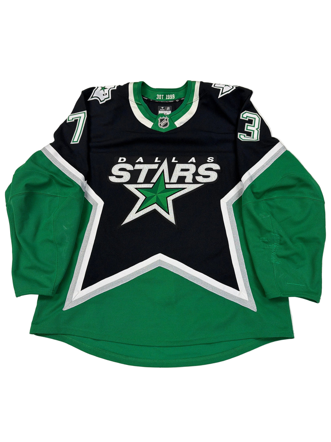 Green and black sports jersey with star design on a white surface