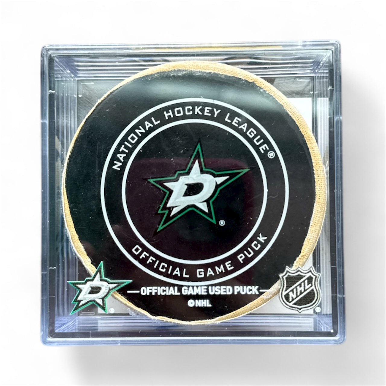 Hockey puck with Dallas Stars and NHL logos in a clear case on a white background