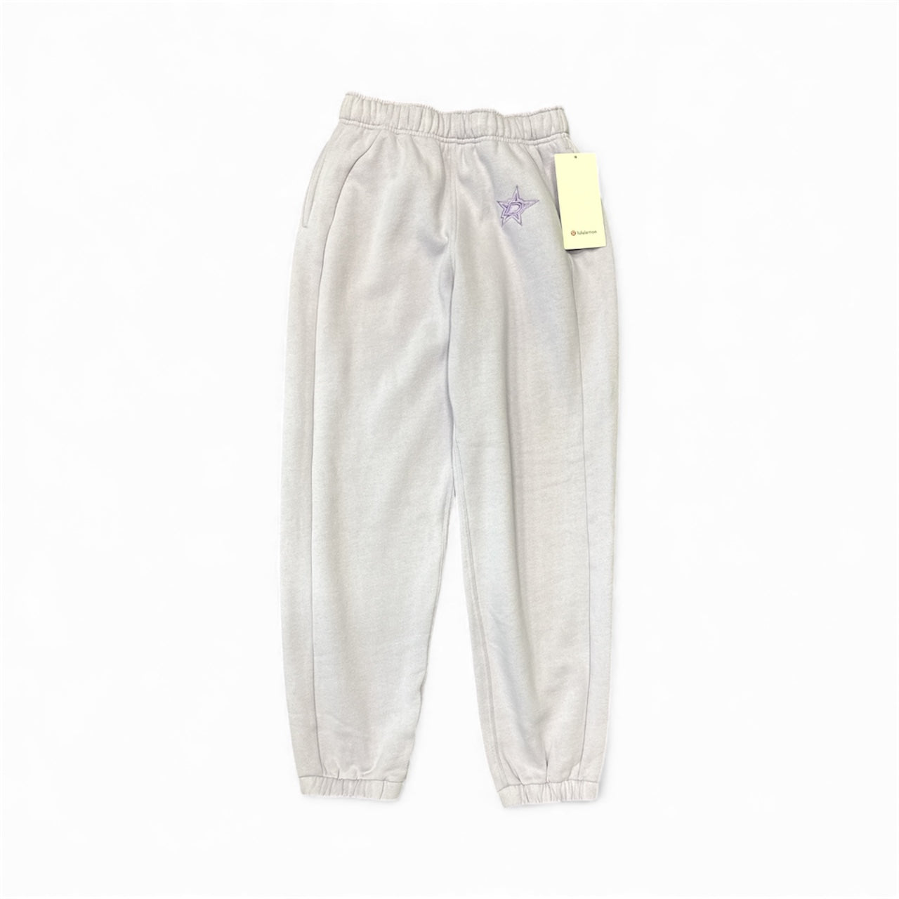 Lilac sweatpants with a brand tag on a white background