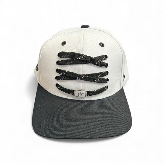 Black and white cap with hockey lace design on a white background