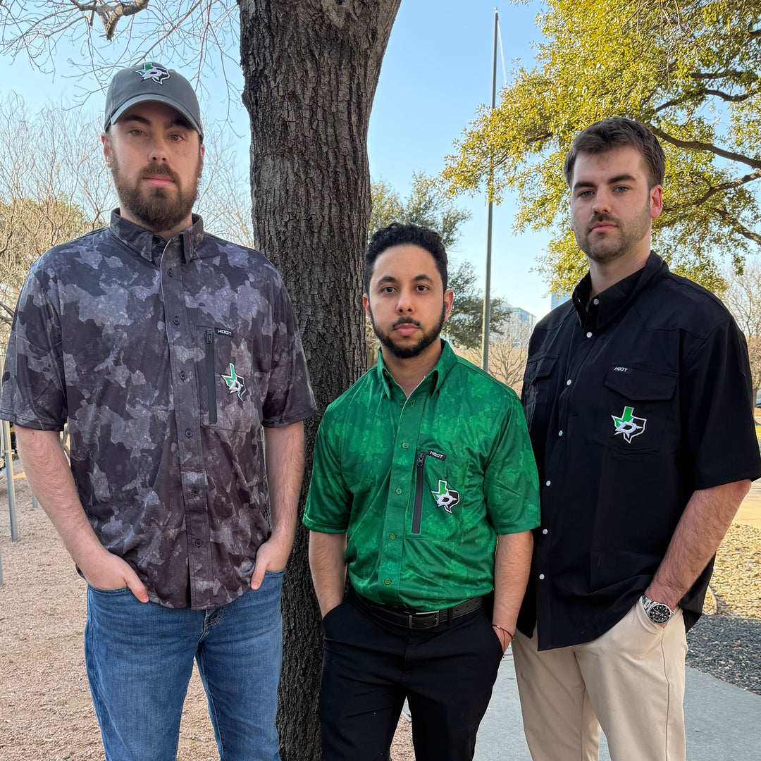 Four people standing outdoors on a tree-lined street.