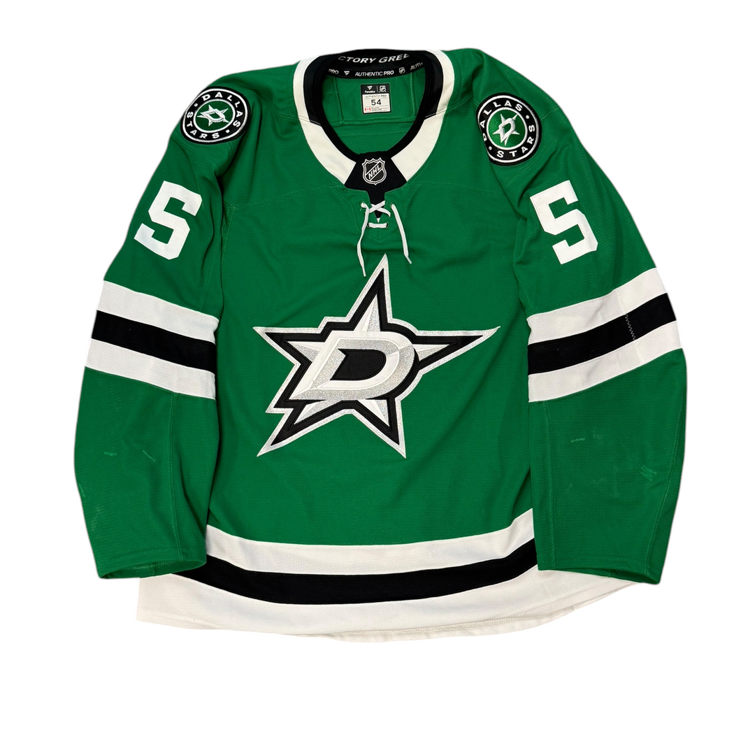 Game Worn Dallas Stars Home hockey jersey with number 5 on sleeves and Stars logo on chest with a white background