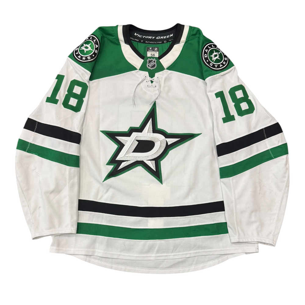 Game Worn Dallas Stars Away jersey with Stars logo on chest and number 18 on the sleeves. Jersey on a white background.