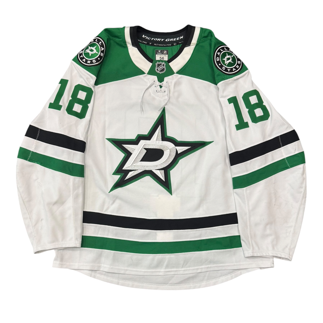 Game Worn Dallas Stars Away jersey with Stars logo on chest and number 18 on the sleeves. Jersey on a white background.