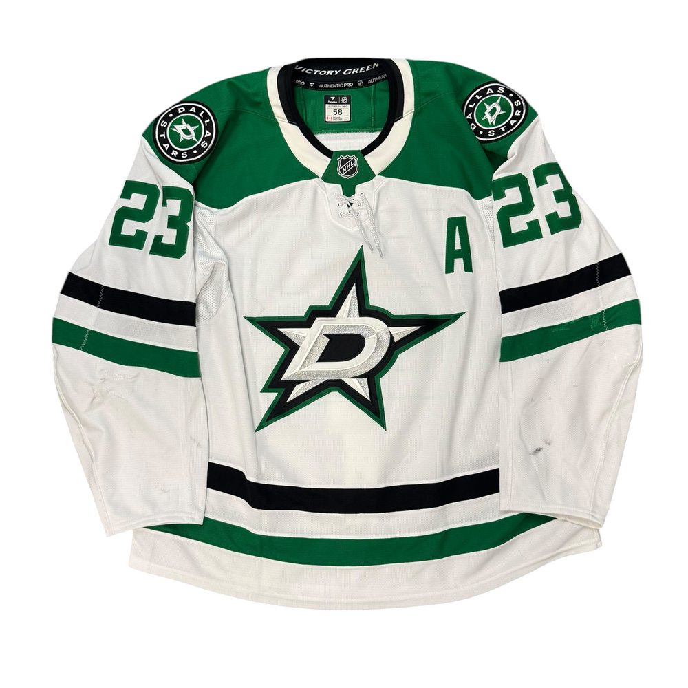 Game Worn Dallas Stars Away jersey with Stars logo on chest and number 23 on the sleeves. Jersey on a white background.