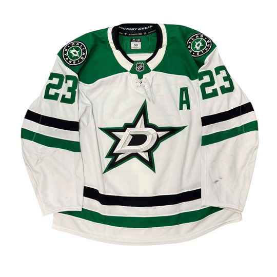 Game Worn Dallas Stars Away jersey with Stars logo on chest and number 23 on the sleeves. Jersey on a white background.
