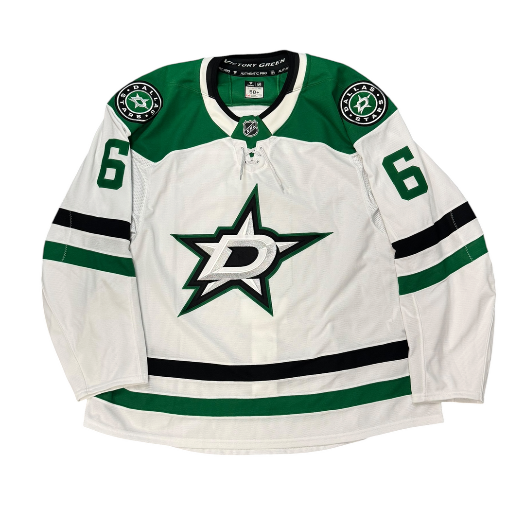 Game Worn Dallas Stars Away jersey with Stars logo on chest and number 6 on the sleeves. Jersey on a white background.