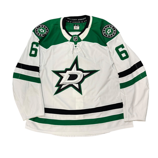 Game Worn Dallas Stars Away jersey with Stars logo on chest and number 6 on the sleeves. Jersey on a white background.
