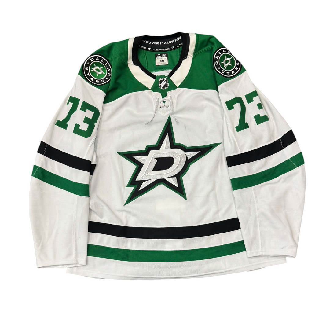 Game Worn Dallas Stars Away jersey with Stars logo on chest and number 73 on the sleeves. Jersey on a white background.