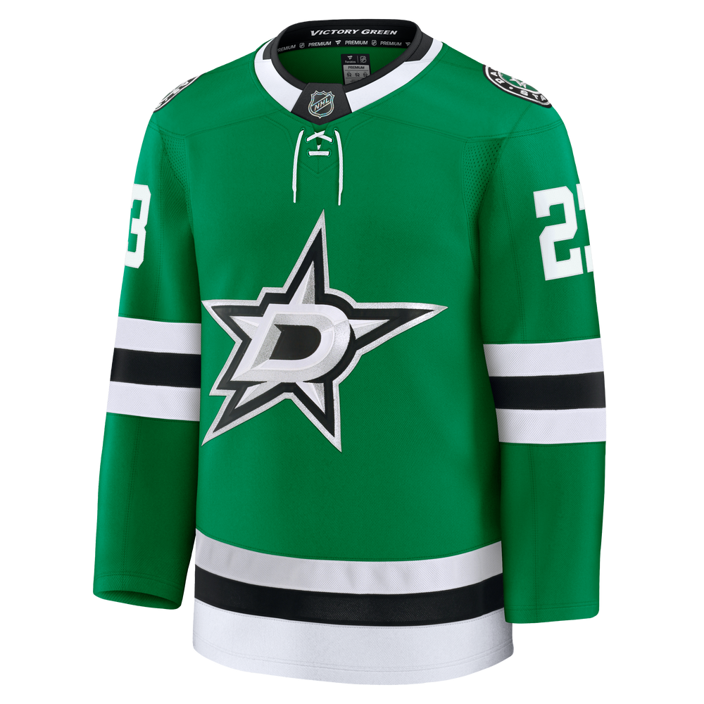 A green Dallas Stars hockey jersey with white and black accents, featuring the team's star logo on the chest and player numbers 23 on the sleeves.