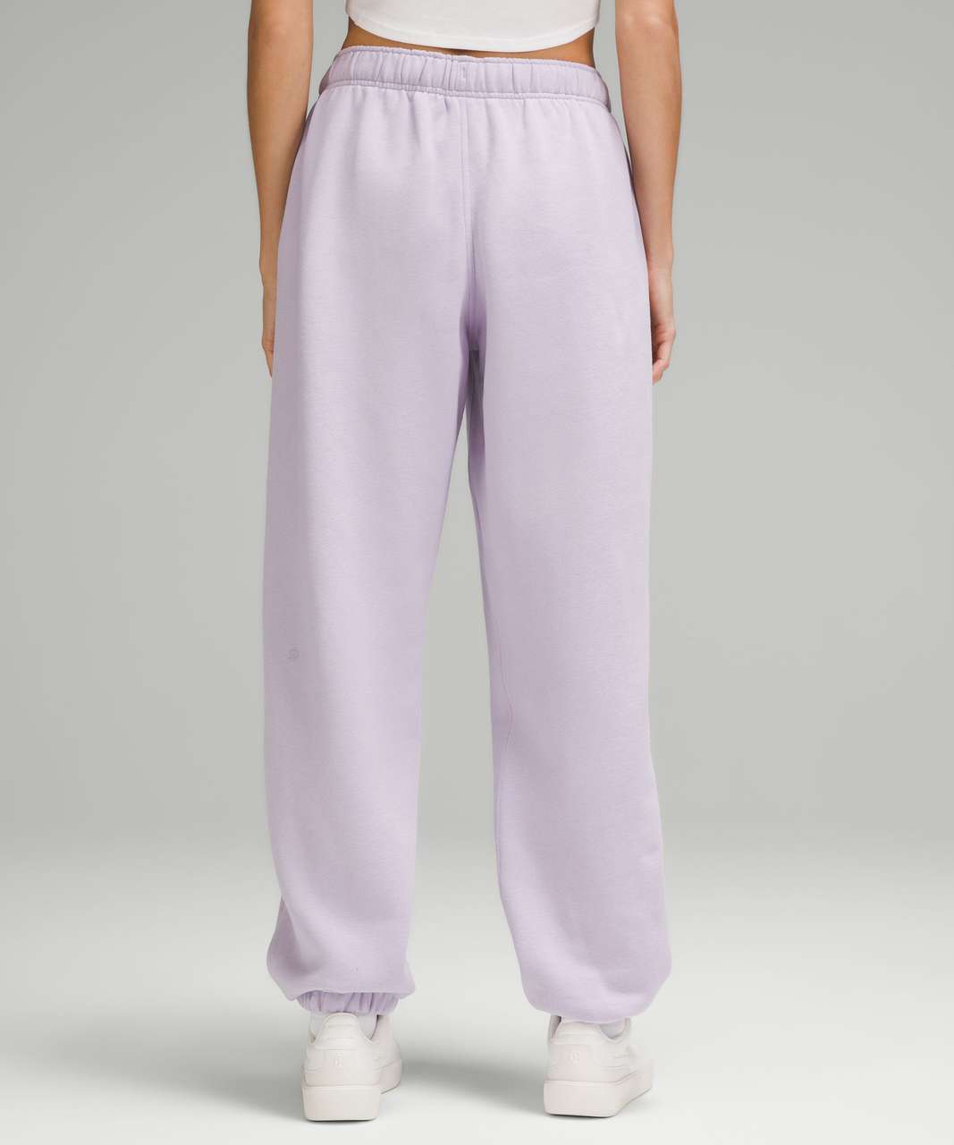 Person wearing lilac sweatpants on a plain background
