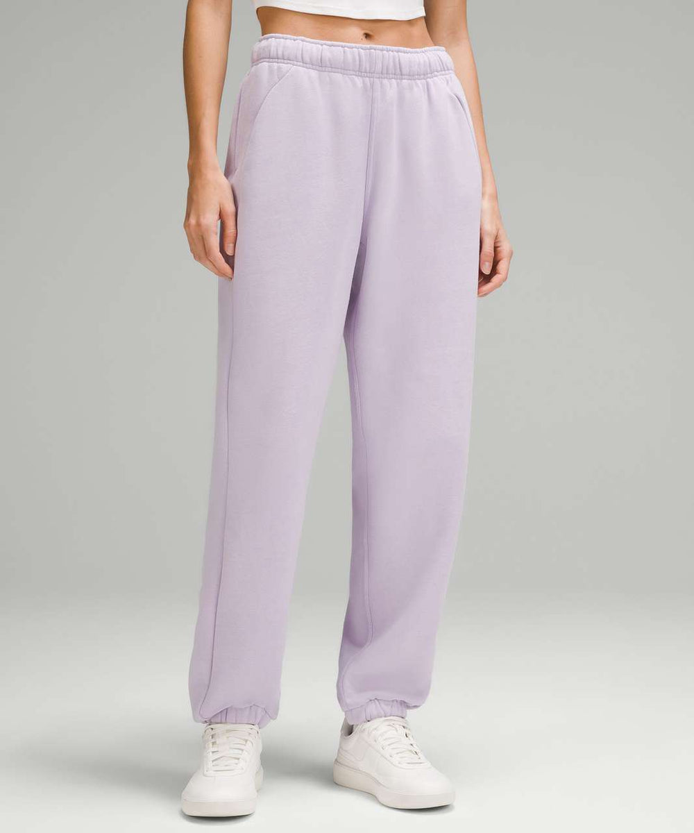 Person wearing lilac sweatpants on a plain background