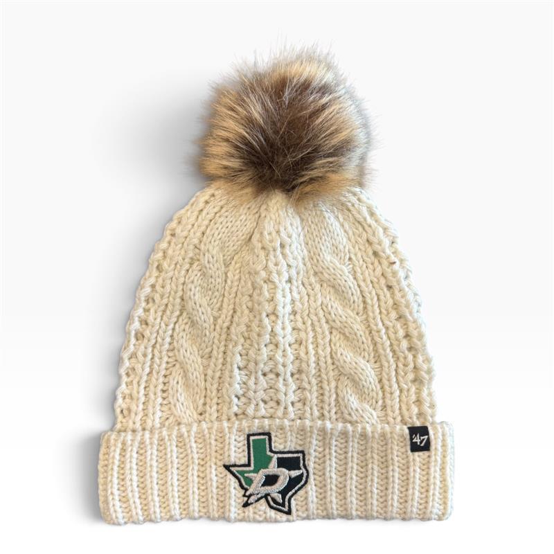 A cream-colored cable-knit beanie with a brown faux fur pom-pom on top. The front cuff features a green and black TX DALLAS STARS, and a small black &