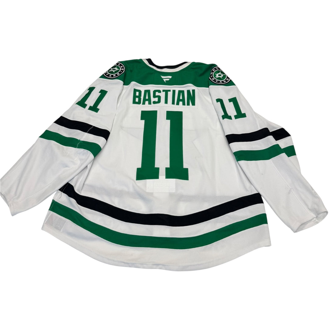 Game worn Dallas Stars away jersey with number 11 and name 'Bastian'. Jersey on a white background
