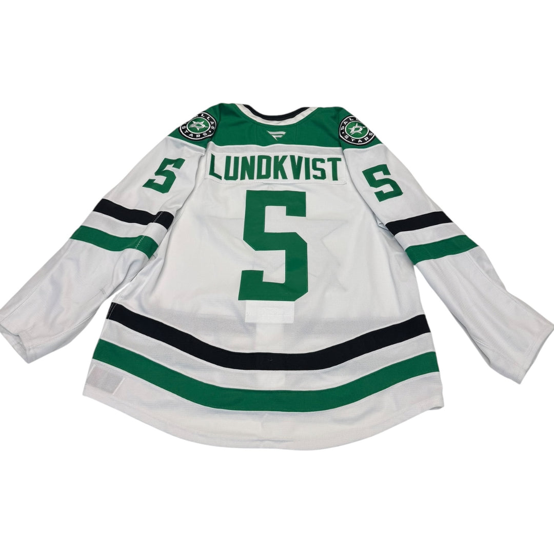 Game worn Dallas Stars away jersey with number 5 and name 'Lundkvist'. Jersey on a white background